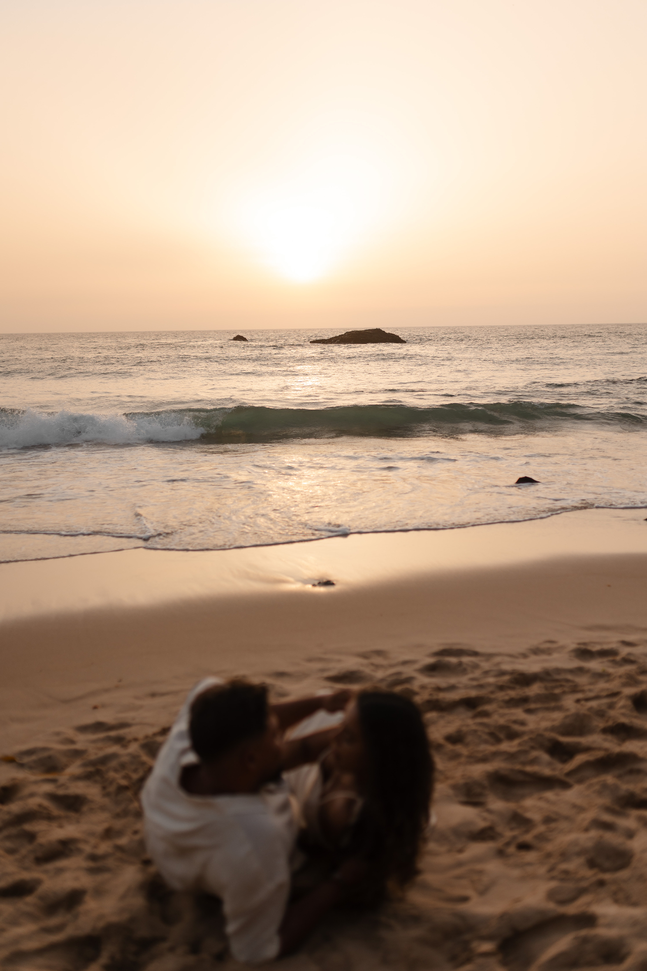 Casal abraçado na praia ao pôr do sol